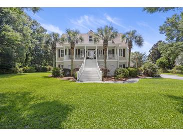 Charming two-story home with a manicured lawn and a grand staircase leading to a welcoming front porch at 7879 Gull Bay Dr, Awendaw, SC 29429
