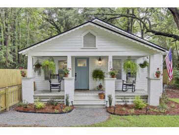Charming cottage featuring rocking chairs and hanging plants on the welcoming front porch at 920 Simmons Ave, Summerville, SC 29483