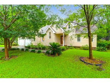 Charming two-story home featuring a well-manicured lawn and mature trees at 112 Fox Chase Dr, Goose Creek, SC 29445