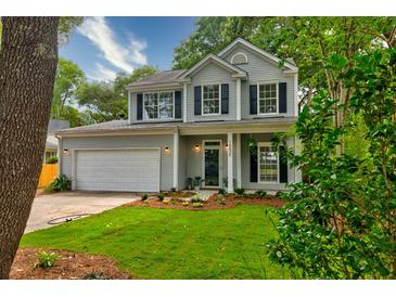 Charming two-story home with a well-manicured lawn and black shutters for a classic look at 1552 Harborsun Dr, Charleston, SC 29412