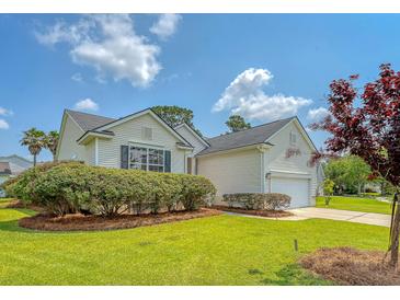 Charming single-Gathering home features lush landscaping, an attached garage, and a well-maintained lawn at 1800 Palmetto Isle Dr, Mount Pleasant, SC 29466