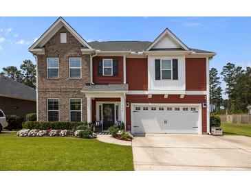 Inviting two-story home featuring brick and red siding, attached two-car garage, and manicured lawn at 255 Saxony Loop, Summerville, SC 29486