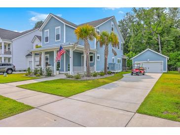 Charming two-story home with light blue siding, a manicured lawn, palm trees, and a long driveway at 2710 Mcfadden Way, Johns Island, SC 29455