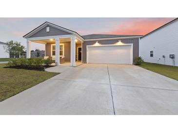 Charming single-Gathering home featuring a covered porch, attached garage, and a well-manicured lawn at 286 W Bradford Pointe Dr, Summerville, SC 29486