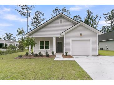 Charming single-story home featuring gray siding, a one-car garage, and a well-manicured front yard at 3214 Pinewood Dr, Ladson, SC 29456