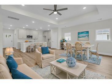 Bright, open-concept living and dining area featuring stylish coastal decor and ample natural light at 3218 Pinewood Dr, Ladson, SC 29456