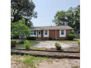 Charming brick home featuring manicured landscaping and mature trees in a desirable neighborhood at 4029 Karen Dr, North Charleston, SC 29405