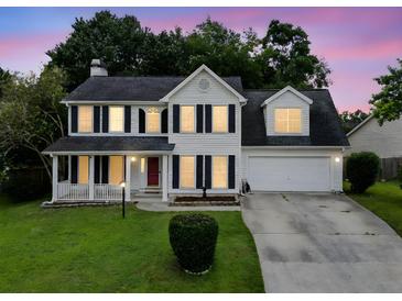 Charming two-story home with a well-manicured lawn, cozy front porch, and attached two-car garage at 103 Retriever Ln, Goose Creek, SC 29445
