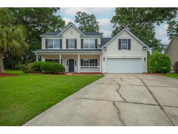 Charming two-story home with a well-manicured lawn, inviting front porch, and attached garage provides an inviting curb appeal at 106 Brandy Ct, Summerville, SC 29485