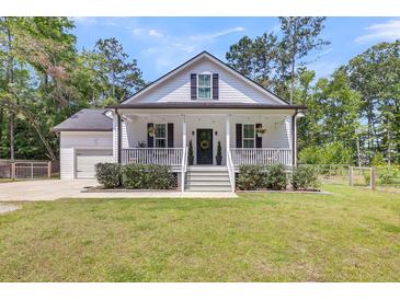 Charming home with a welcoming front porch, manicured lawn, and beautiful landscaping at 119 White Picket Ln, Summerville, SC 29483