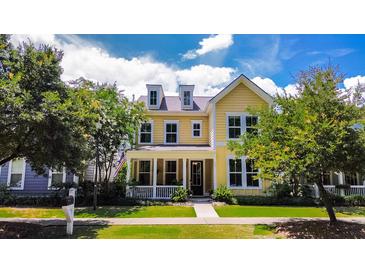 Charming two-story yellow home with dormer windows and a welcoming front porch at 157 Village Ponds Dr, Summerville, SC 29483