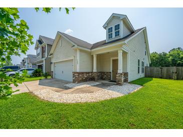 Charming two-story home features manicured lawn, attached garage, and welcoming front porch at 1689 Eider Down Dr, Summerville, SC 29483