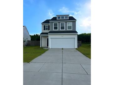 Charming two-story home with a two-car garage and manicured lawn, perfect for suburban living at 242 Torslanda Ln, Summerville, SC 29486