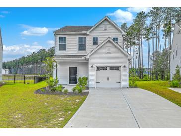 Charming two-story home features a clean white facade, attached garage, and well-manicured landscaping at 523 Purple Finch Rd, Summerville, SC 29486