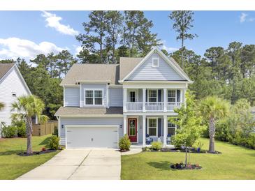 Charming two-story home featuring a welcoming front porch, well-manicured lawn, and attached two-car garage at 5541 Alpine Dr, Summerville, SC 29483