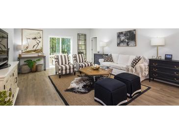 Bright living room with hardwood floors, stylish furniture, and natural light from sliding glass doors at 604 Quiet Valley Rd, Summerville, SC 29486