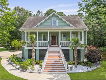 Charming two-story home featuring a wide front porch, decorative columns, and beautiful landscaping at 800 Enclave Ter, Summerville, SC 29483