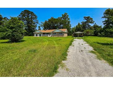 Charming brick home with a well-maintained lawn and a detached garage on a sunny day at 840 Brittle Bank Rd, Walterboro, SC 29488