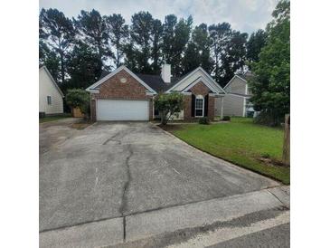 Charming one-story brick home with a well-manicured lawn and an attached two-car garage at 8420 Walsham St, North Charleston, SC 29420