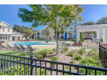 A beautiful community pool with lounge chairs, a pergola and lush landscaping on a sunny day at 1014 Rosewood Ln, Mount Pleasant, SC 29464