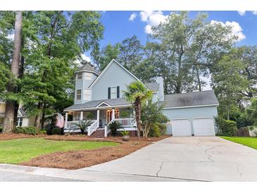 Charming two-story home boasts a welcoming front porch, mature trees, and a well-manicured lawn at 111 Long Bow Rd, Summerville, SC 29485