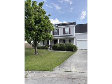 Charming two-story home featuring a well-manicured lawn, mature landscaping, and a welcoming front porch at 113 Lebsl Ct, Summerville, SC 29483