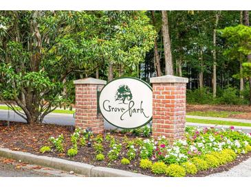 Grove Park entrance sign with brick pillars, manicured flower beds, and lush trees enhancing the welcoming curb appeal at 401 S Elgin Ct # 401, Charleston, SC 29414