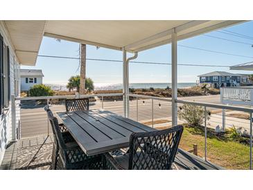 Inviting outdoor dining space with ocean views from covered porch at 405 Palmetto Blvd, Edisto Island, SC 29438