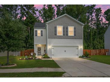 Charming two-story home with a well-manicured lawn and a two-car garage, situated beneath a captivating dusk sky at 508 Glady Rd, Moncks Corner, SC 29461