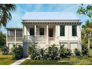 Charming coastal home featuring a white exterior, inviting front porch, and lush tropical landscaping at 7059 Sounding Ln, Johns Island, SC 29455