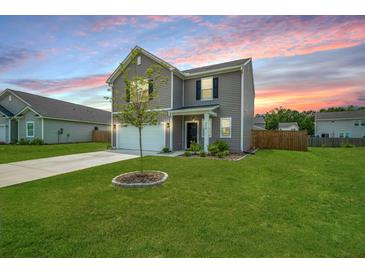 Beautiful two-story home featuring a well-manicured lawn and attached two-car garage at 716 Mcroy St, Moncks Corner, SC 29461