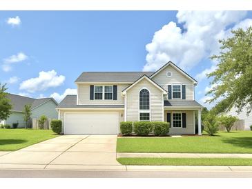 Charming two-story home with a well-manicured lawn and a two-car garage under a blue sky with fluffy white clouds at 113 Rockdale Ln, Goose Creek, SC 29445