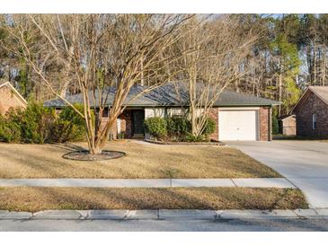 Charming single-story brick home featuring a well-maintained yard and attached garage at 113 Surrey Dr, Summerville, SC 29486