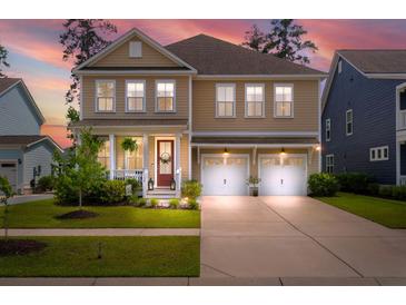 Charming two-story home featuring a welcoming front porch and a convenient two-car garage at 154 Calm Water Way, Summerville, SC 29486