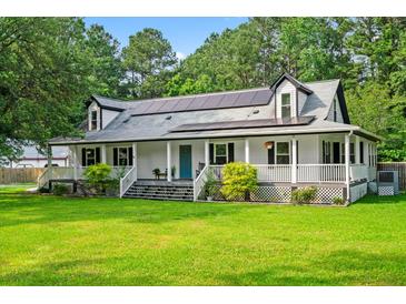 Charming two-story home featuring a welcoming front porch, solar panels, and a lush green lawn at 162 Whippoorwill Dr, Summerville, SC 29483
