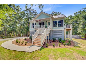Charming two-story beach house with a welcoming porch and lush landscaping at 18 Tupelo Trl, Edisto Island, SC 29438