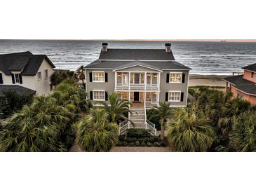 Elegant beachfront home featuring a charming front porch, palm trees, and picturesque ocean views at 210 Ocean Blvd, Isle of Palms, SC 29451