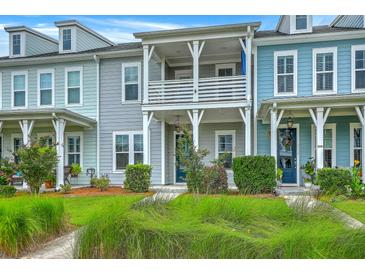 Charming townhomes featuring colorful exteriors, a second story porch, and well-maintained landscaping at 3125 Sturbridge Rd, Mount Pleasant, SC 29466