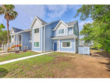 Charming blue two-story townhome featuring shingle and siding accents, well-manicured landscaping, and a welcoming entryway at 851 Sandlake Dr # D, Mount Pleasant, SC 29464