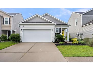 Charming home featuring a two-car garage, yellow front door, and well-maintained landscaping at 9712 Fanning Basket Ln, Ladson, SC 29456