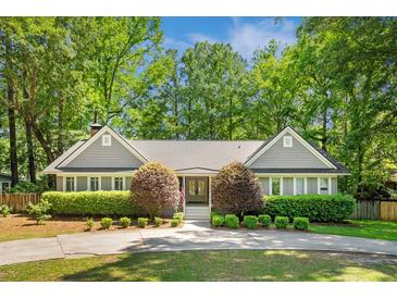 Charming home featuring a lush, landscaped front yard with mature trees and a circular driveway at 1061 Law Ln, Mount Pleasant, SC 29464