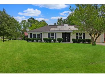 Charming single-story home with solar panels, lush lawn and manicured shrubs at 1101 Stuart Dr, Moncks Corner, SC 29461