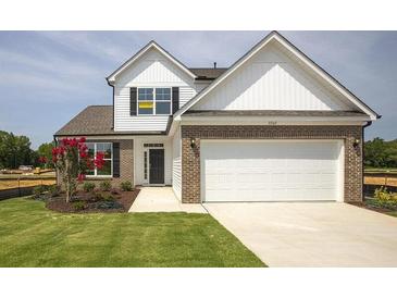 Charming two-story home featuring a brick and siding facade, well-manicured lawn, and an attached two-car garage at 124 Palfrey Dr, Ridgeville, SC 29472