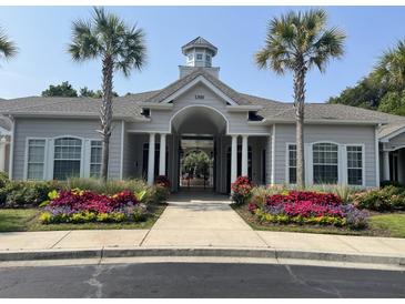 Beautiful clubhouse exterior featuring palm trees and colorful landscaping at 1300 Park West Blvd # 822, Mount Pleasant, SC 29466