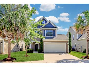 Charming two-story home with a well-manicured lawn, a two-car garage, and mature palm trees at 1484 Milldam Pass, Johns Island, SC 29455