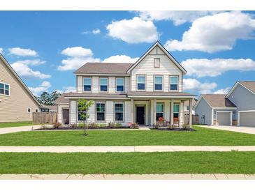 Charming two-story home featuring a well-manicured lawn, inviting front porch, and classic architectural details at 2064 Parish House Cir, Johns Island, SC 29455