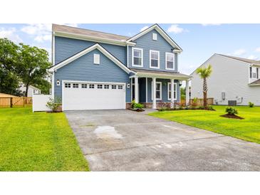 Charming two-story home showcasing manicured lawn, blue siding, and a well-lit two car garage and driveway at 3010 Grinnell St, Johns Island, SC 29455