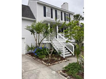 Charming two-story home with landscaped yard, white stairs, and inviting front porch at 324 Wild Horse Ln, Mount Pleasant, SC 29464