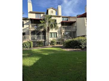 Multi-story building with balconies, awnings, and well-maintained landscaping, offering a blend of comfort and curb appeal at 410 Yacht Harbor Ct # 410, Isle of Palms, SC 29451