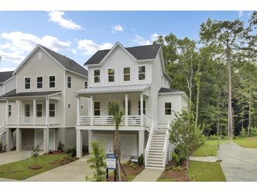 Charming two-story home with white siding, covered porch, and well-manicured landscaping at 615 Du Bois Dr, Johns Island, SC 29455
